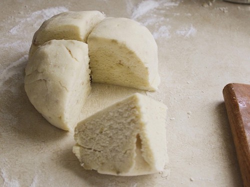 Gluten-free gnocchi dough divided into four pieces.