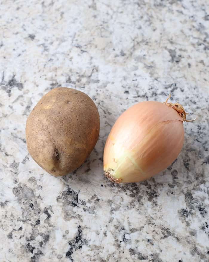Potato and onion on a counter.