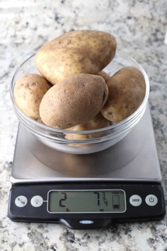Potatoes on digital scale. Weight reading shows two pounds seven and three quarters ounces.