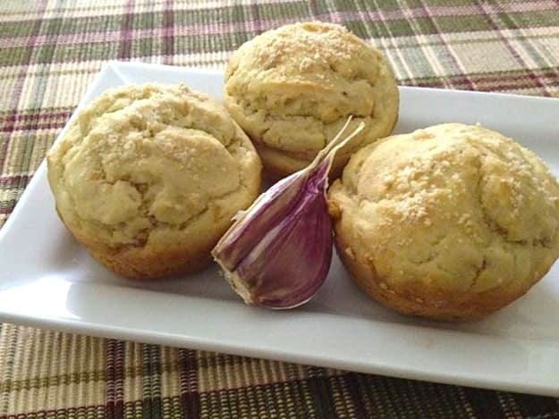 Three gluten-free onion and garlic muffins on a tray.