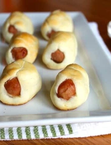 Gluten-Free Pigs in a Blanket on a white platter.