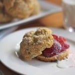 Gluten-Free Shortcake, split and topped with strawberries and a drizzle of cream.