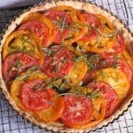 Gluten-Free Tomato Tart on a wire rack. The tart is topped with shredded basil.