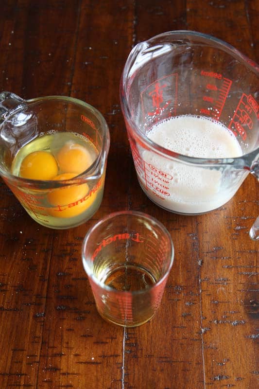 Measuring cup with eggs. Measuring cup with yeast mixture. Measuring cup with oil.