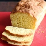 Loaf of Baked Gluten-Free Sandwich Bread on Red Cutting Board.
