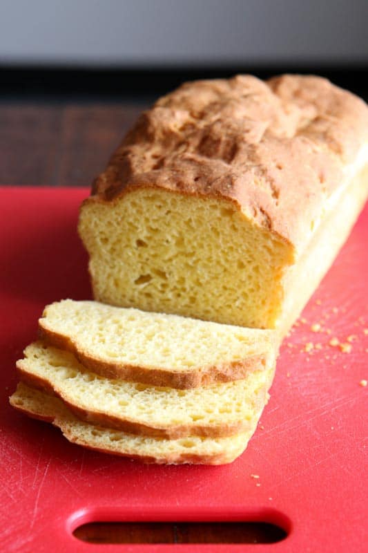 Loaf of Baked Gluten-Free Sandwich Bread on Red Cutting Board. 