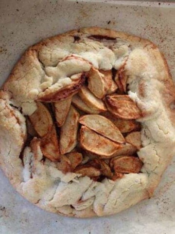 Rustic apple pie on a baking sheet.