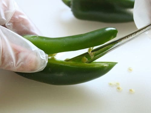 Removing seeds from a jalapeño pepper. 