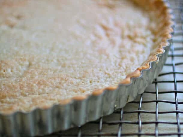 Gluten-free tart shell in pan on cooling rack.