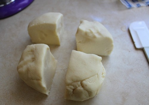 Gluten-free cookie dough cut into four pieces.