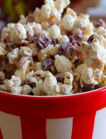 White chocolate popcorn with cranberries in a bowl.