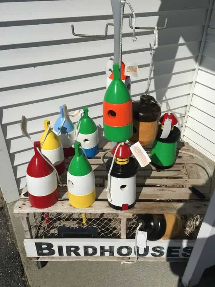 Colorful birdhouses on a lobster trap.