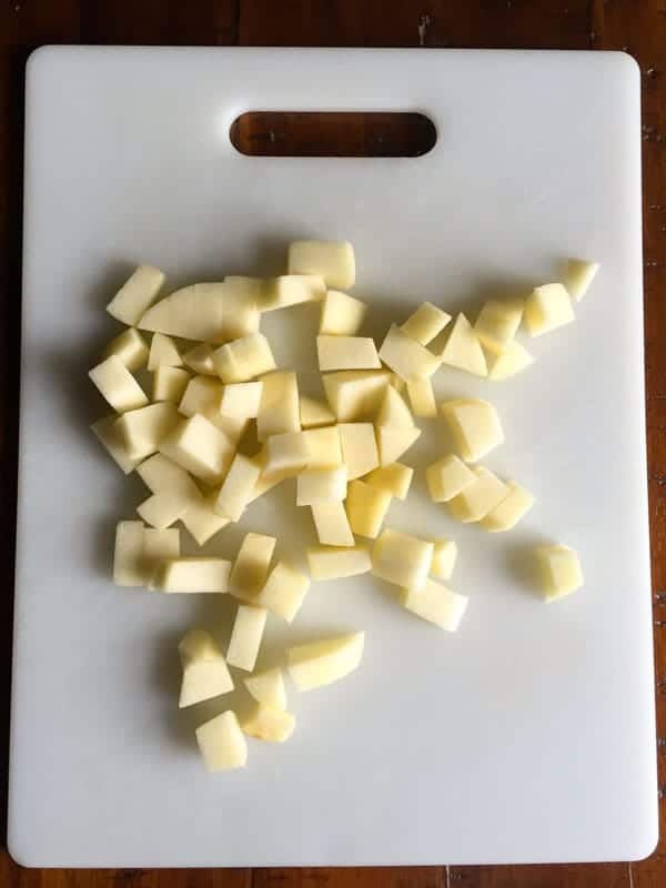 Cut apple pieces on a white cutting board.