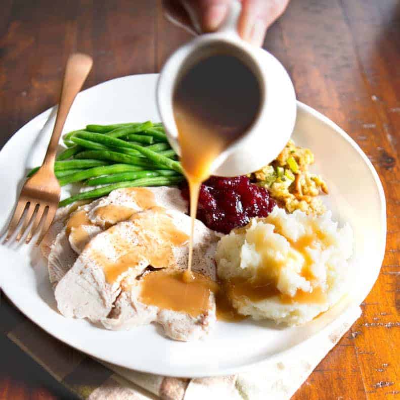 Gluten-free gravy being poured on turkey.