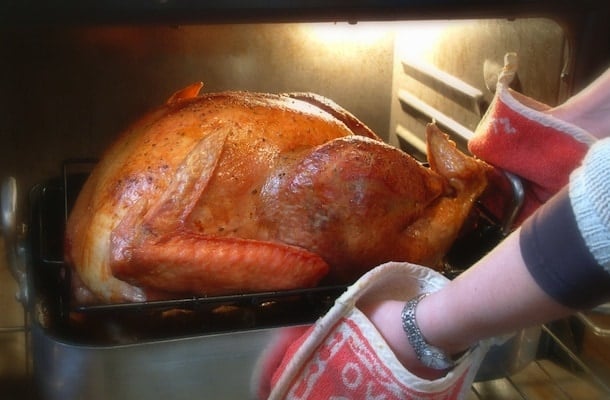 Removing Thanksgiving turkey from oven.