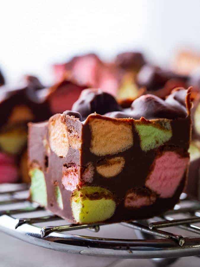 Chocolate marshmallow bar with colorful fruity marshmallows on wire rack. 