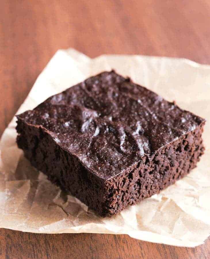Paleo brownie on a brown piece of parchment paper.