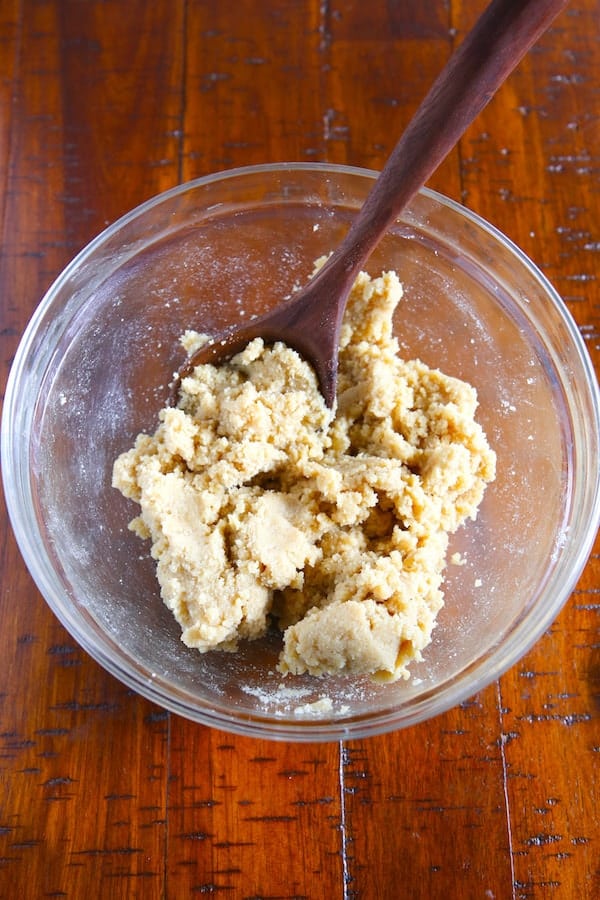 World's easiest cookie dough in glass bowl with wooden spoon.