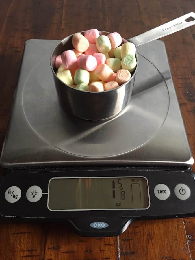 Cup of marshmallows on a digital scale. Display reads 1 5/8 ounces.