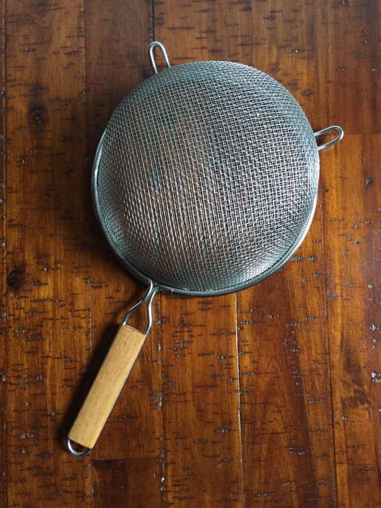 Metal sifter with wooden handle.