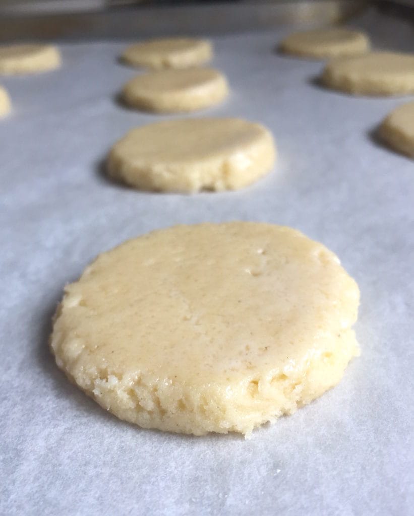 Gluten-free soft sugar cookie dough on a baking sheet. Dough has been pressed and flattened.