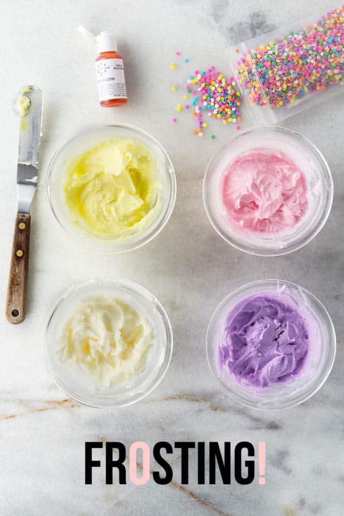 Four bowls of colored frosting with sprinkles on a marble board. Text on image reads: frosting.