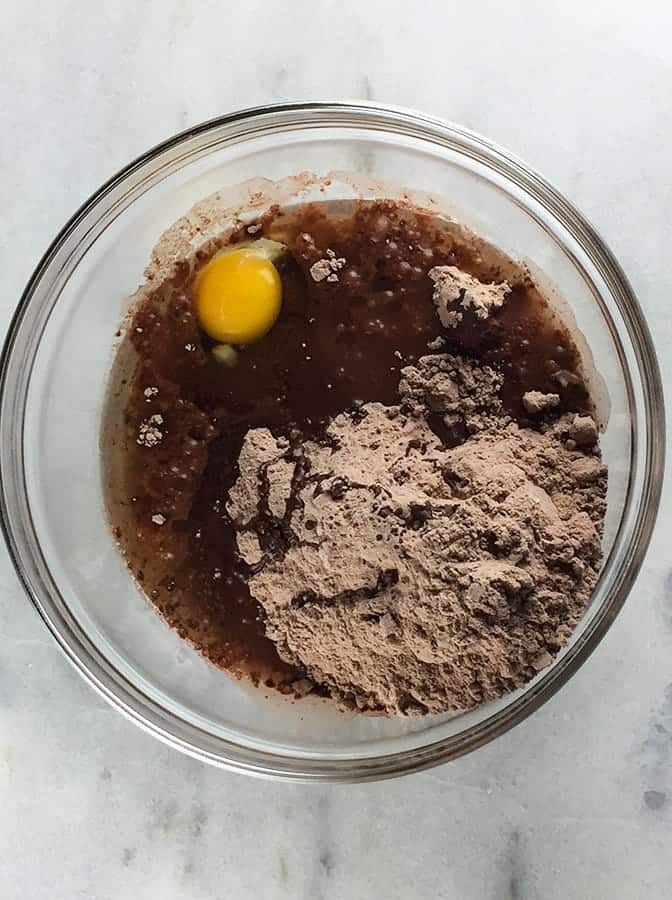Krusteaz gluten free double chocolate brownie mix in a bowl with oil and an egg.