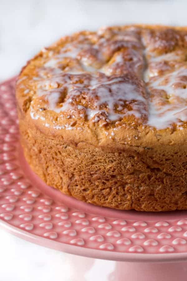 Gluten-free Italian Easter bread on pink cake stand. Bread is topped with vanilla glaze.