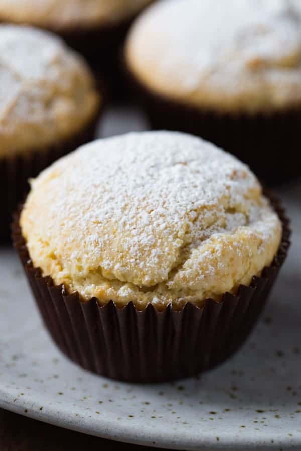 Gluten-free sour cream muffins topped with powdered sugar.