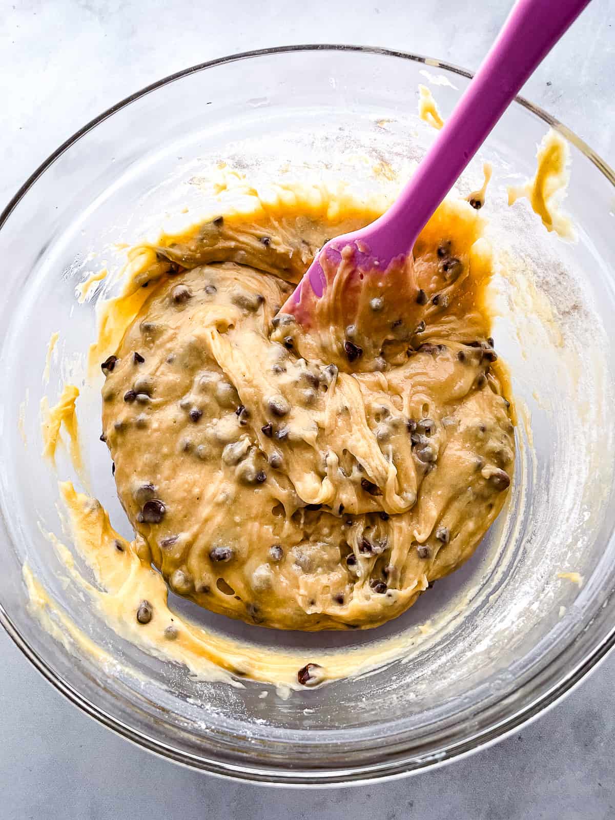 Gluten-free chocolate chip muffin batter in a glass bowl.