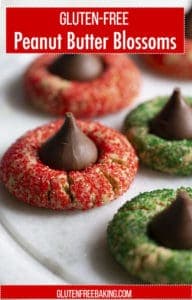 Gluten-Free Peanut Butter Blossoms. Image shows peanut butter cookies rolled in red and green sugar topped with a Hershey's kiss.