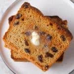 Stack of toasted cinnamon raisin bread slices. Melted butter on top slice.