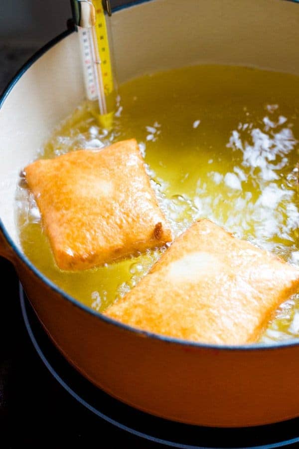 Frying gluten-free beignet in hot oil.