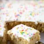 Gluten-Free Vanilla Sheet Cake. Sliced in Pan. Frosted with Vanilla Frosting and sprinkled with pastel sprinkles.