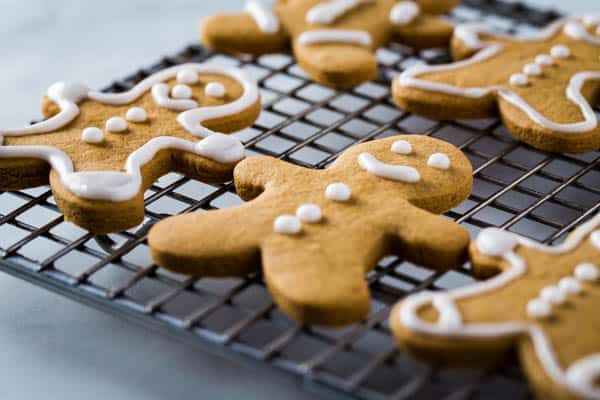 Frosted gluten-free gingerbread cookies on wire rack.
