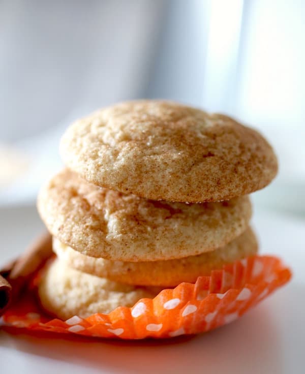 Stack of baked gluten-free snickerdoodles in a orange paper wrapper