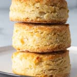 Three gluten-free biscuits stacked on a plate.