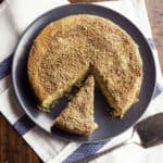 Almond flour coffee cake on plate. One slice is cut from the cake.