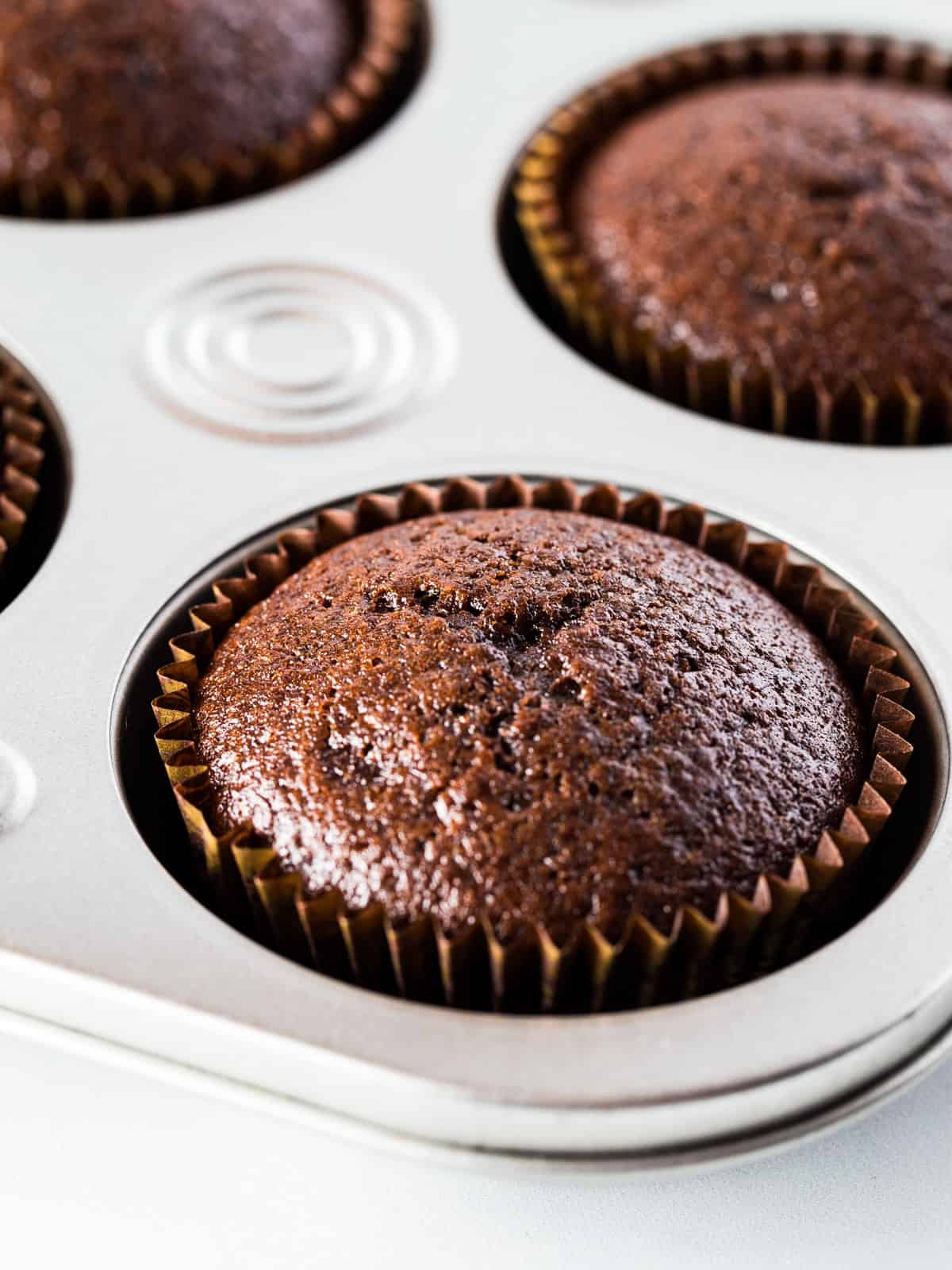 Baked gluten-free chocolate cupcake in cupcake pan.