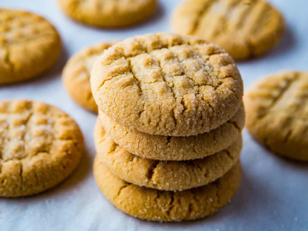 Stack of gluten-free peanut butter cookies on a baking sheet.