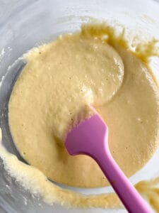 Almond flour pancake batter in a glass bowl with a pink spatula.