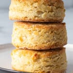 Three gluten free biscuits in a stack on a small plate.