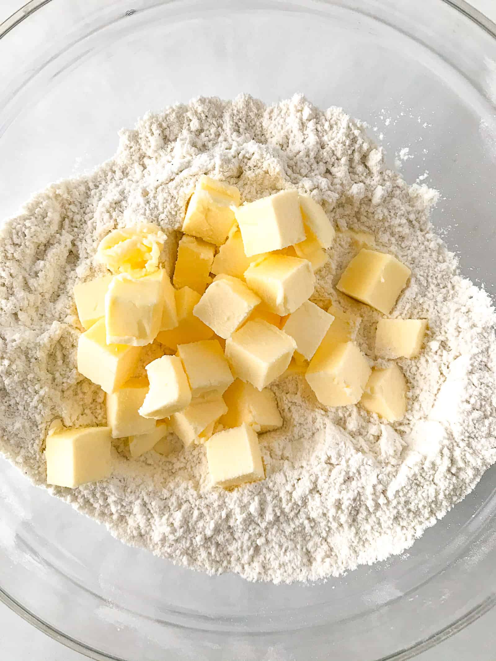 Cubed butter sitting on top of flour for gluten-free biscuits.