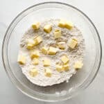 Gluten-free flour with small piece of butter in a glass bowl.