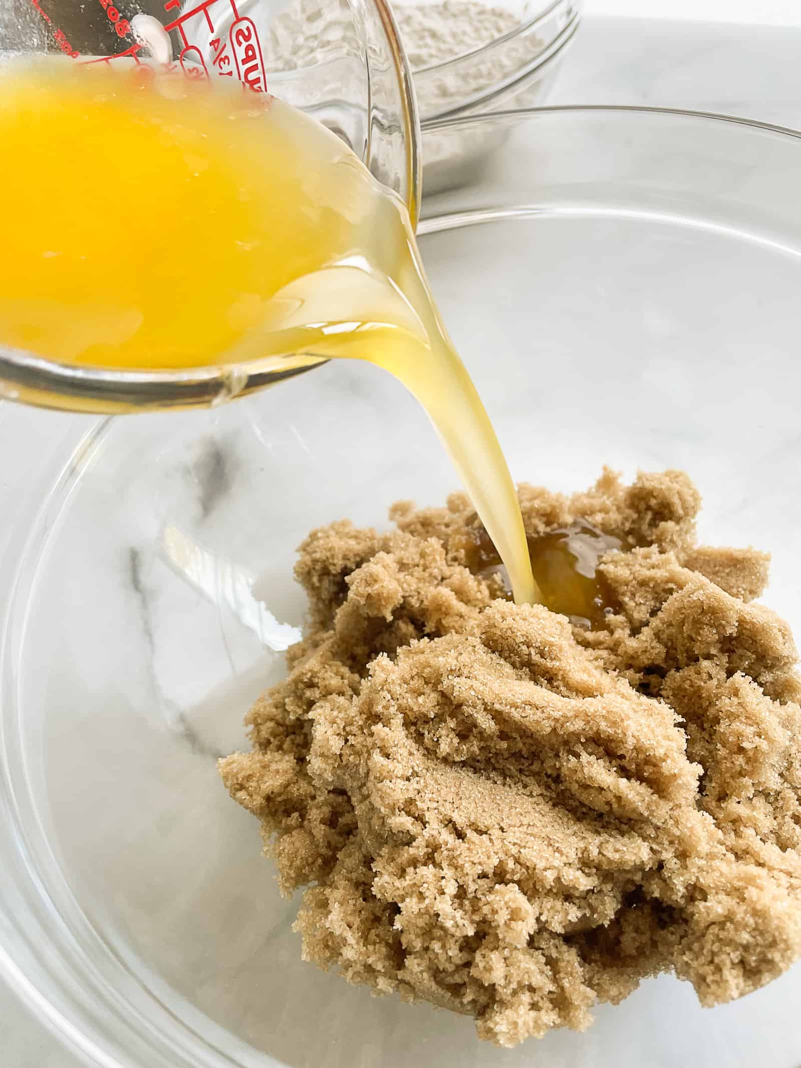 Pouring melted butter into brown sugar.