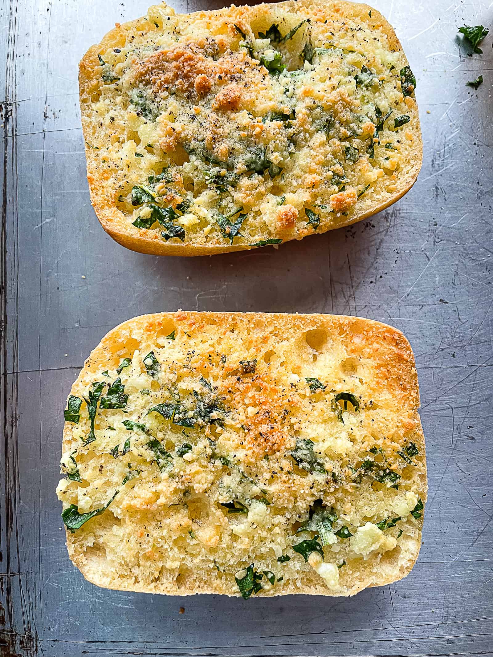 Baked gluten-free garlic bread on a sheet pan.