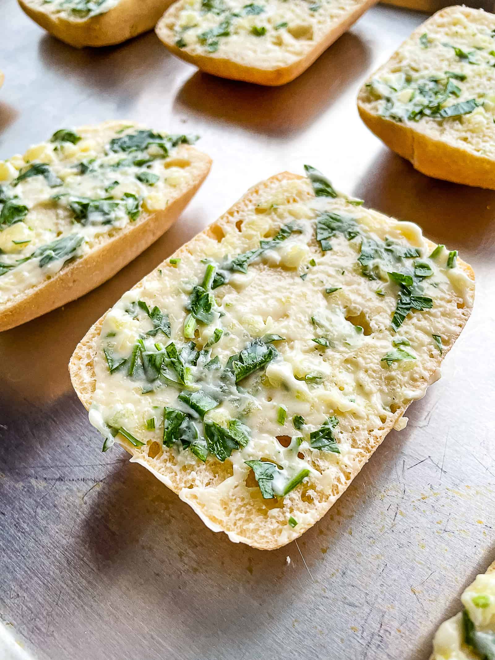 Gluten-free garlic bread on a sheet pan waiting to be baked.