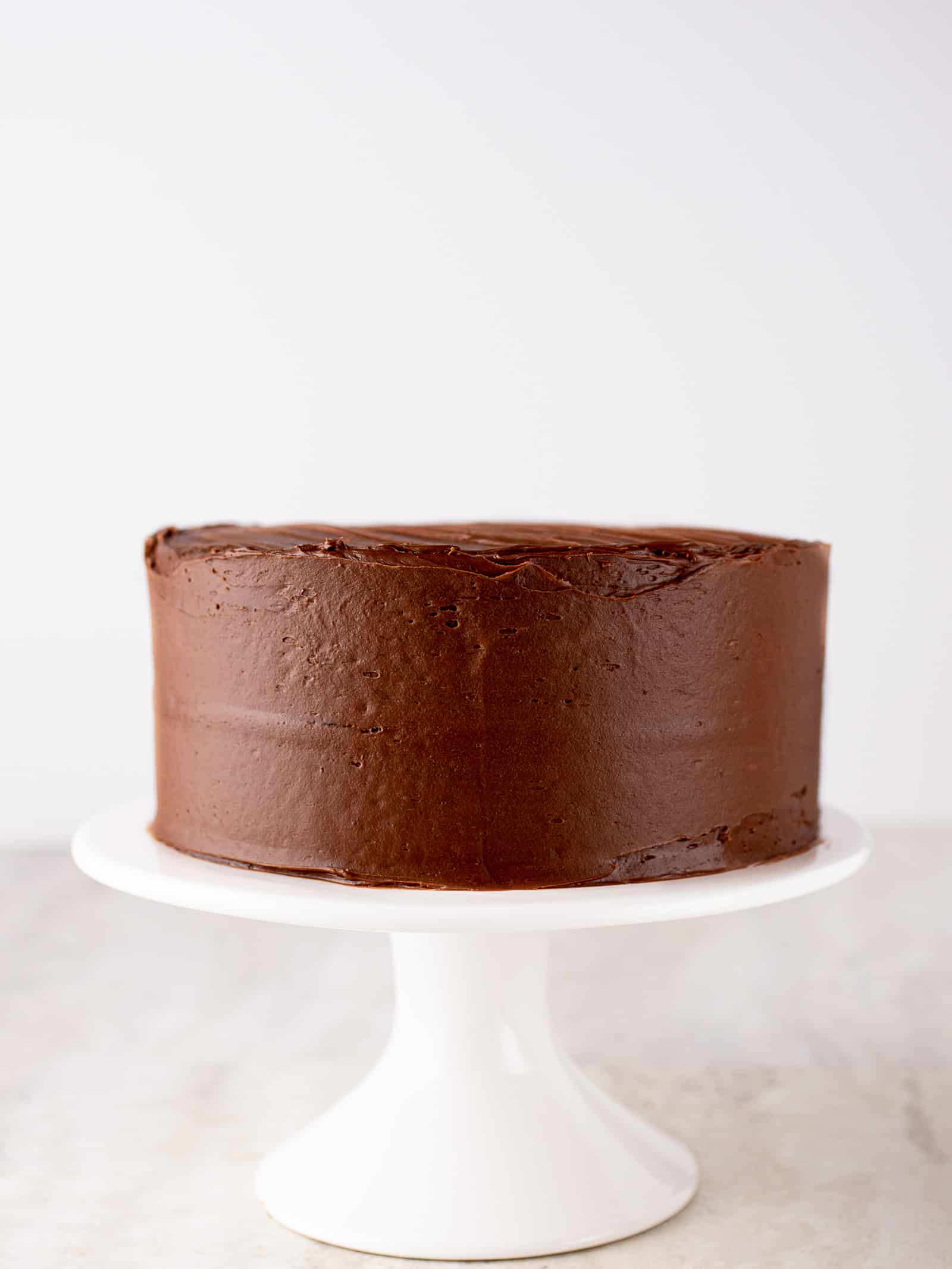 Gluten-free chocolate cake on a cake stand.