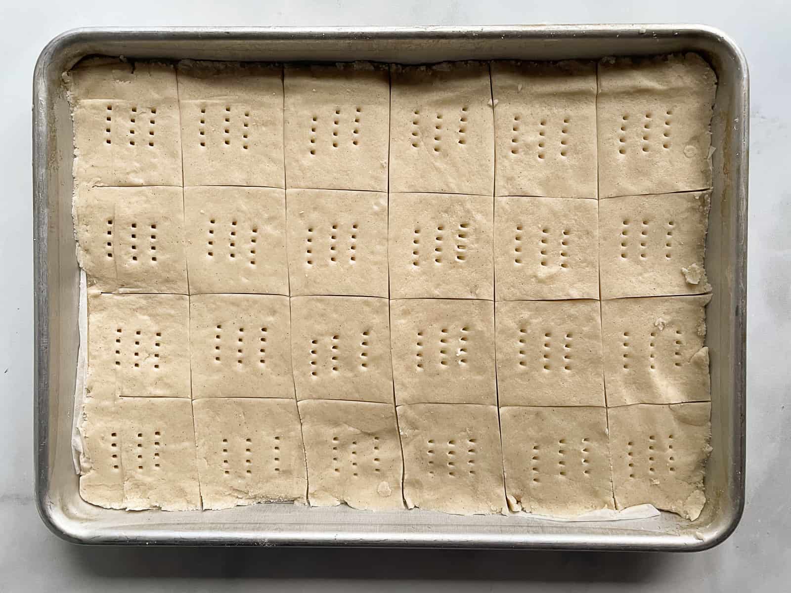 Gluten-free shortbread dough pressed into a pan and scored into squares.
