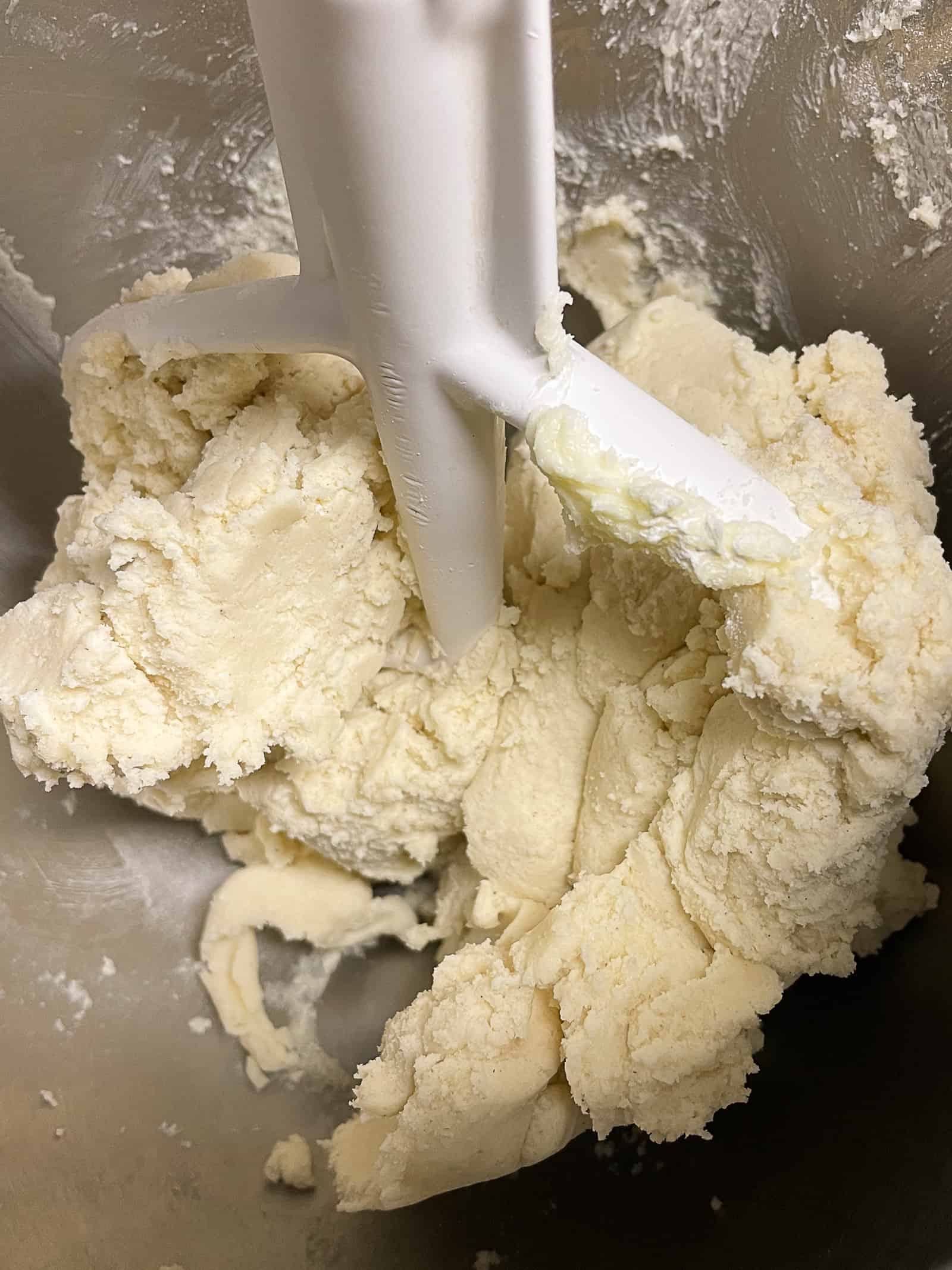 Gluten-free shortbread dough in the bowl of a stand mixer.